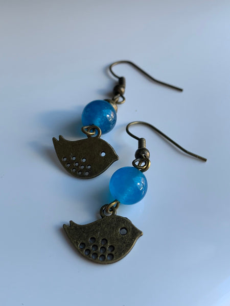 Boucles d’oreilles breloque oiseau bronze et bille de verre bleu Comme un ange