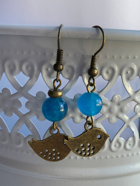 Boucles d’oreilles breloque oiseau bronze et bille de verre bleu Comme un ange