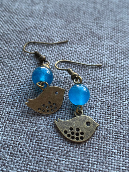 Boucles d’oreilles breloque oiseau bronze et bille de verre bleu Comme un ange