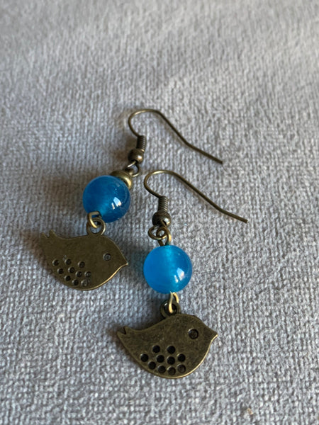 Boucles d’oreilles breloque oiseau bronze et bille de verre bleu Comme un ange