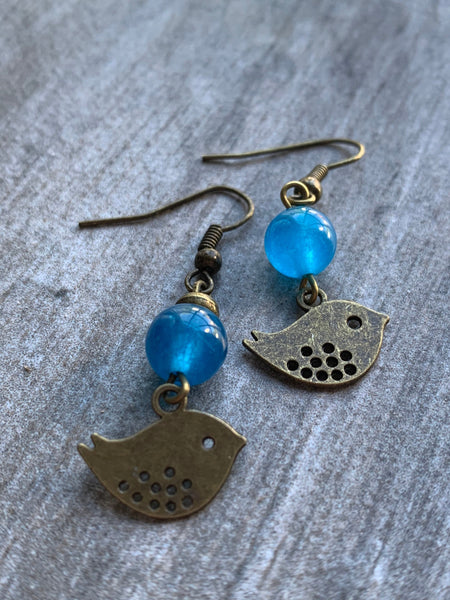 Boucles d’oreilles breloque oiseau bronze et bille de verre bleu Comme un ange