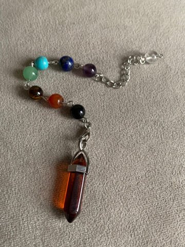 Pendule pierre rouge transparente sur chaîne alliage de métaux argent et billes de verre chackras arc-en-ciel pendulum mystique reiki Comme un ange